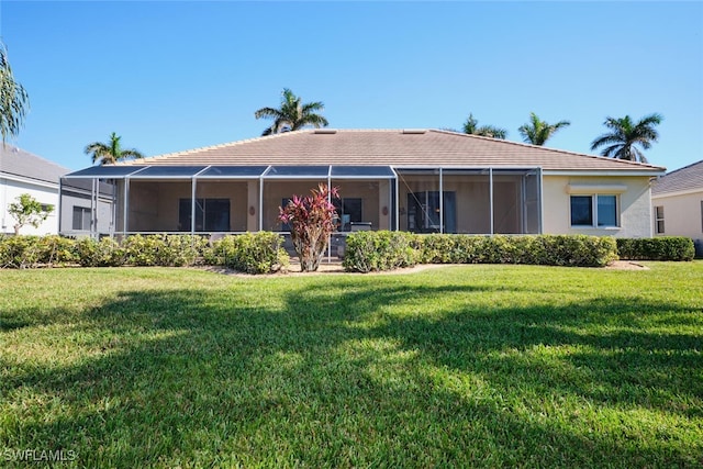 rear view of house with a lanai and a yard