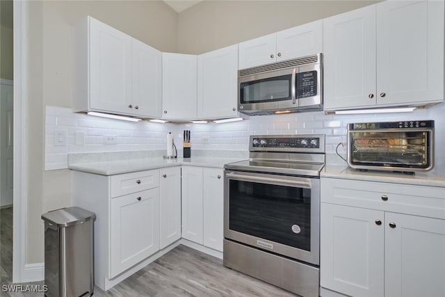 kitchen featuring white cabinets, stainless steel appliances, and light hardwood / wood-style flooring