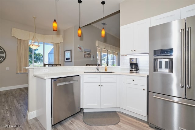 kitchen with a wealth of natural light, white cabinetry, sink, and stainless steel appliances