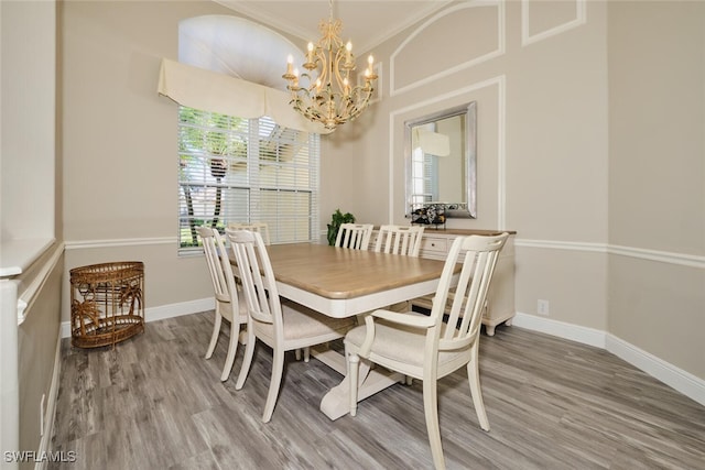 dining room featuring a chandelier, crown molding, and wood-type flooring