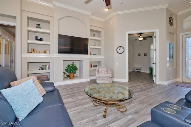 living room with hardwood / wood-style flooring, built in shelves, and ornamental molding