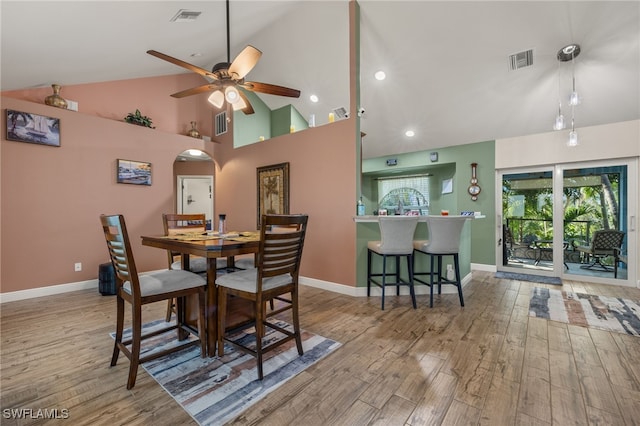 dining room with light wood-type flooring, high vaulted ceiling, and ceiling fan