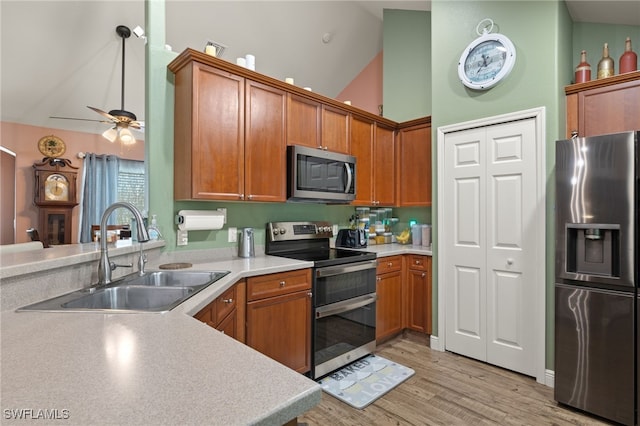 kitchen with stainless steel appliances, ceiling fan, sink, high vaulted ceiling, and light hardwood / wood-style floors