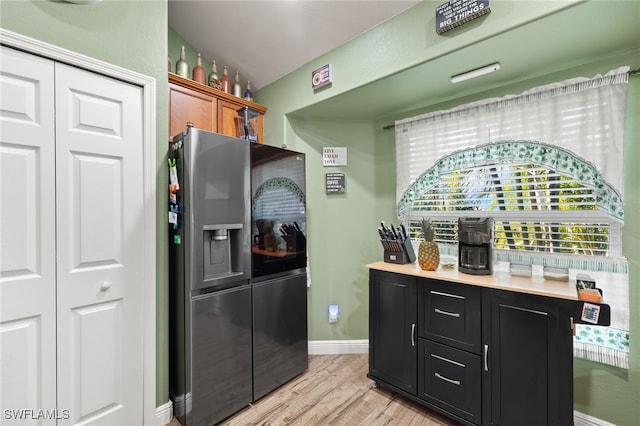 kitchen with light hardwood / wood-style floors and stainless steel refrigerator with ice dispenser