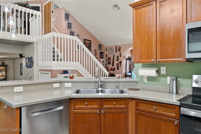 kitchen with kitchen peninsula, appliances with stainless steel finishes, lofted ceiling, and sink