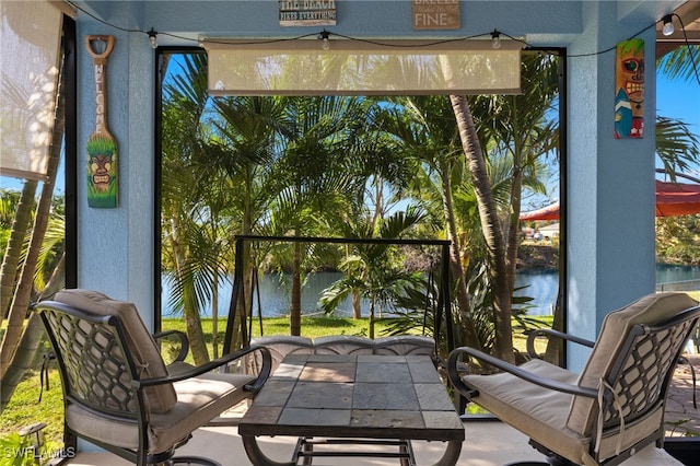 sunroom / solarium featuring a wealth of natural light and a water view