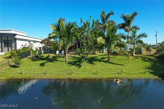 surrounding community with a water view and a yard