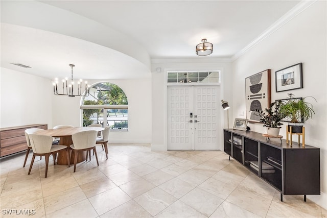 entryway featuring french doors, an inviting chandelier, and ornamental molding