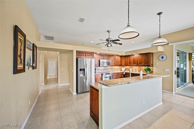 kitchen featuring light stone countertops, stainless steel appliances, decorative light fixtures, decorative backsplash, and light tile patterned floors