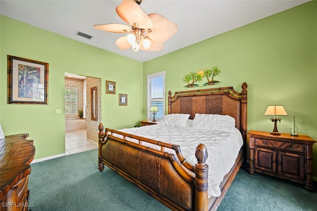 carpeted bedroom with ensuite bathroom and ceiling fan