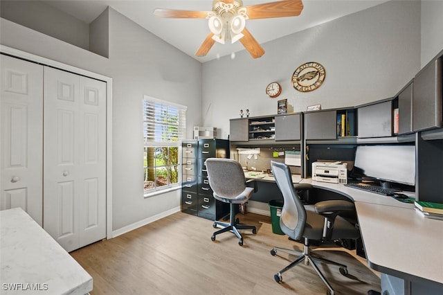 home office with light hardwood / wood-style floors, high vaulted ceiling, and ceiling fan