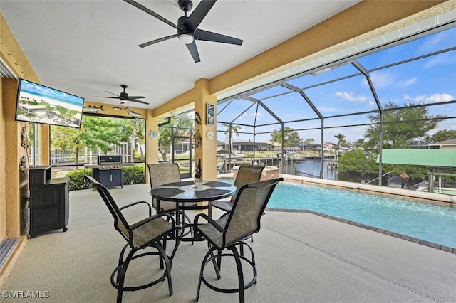 view of pool featuring a patio, a water view, ceiling fan, and a lanai