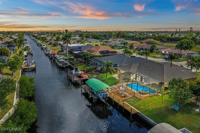 aerial view at dusk featuring a water view