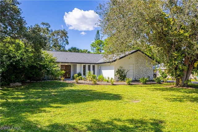 view of front of property featuring a garage and a front lawn