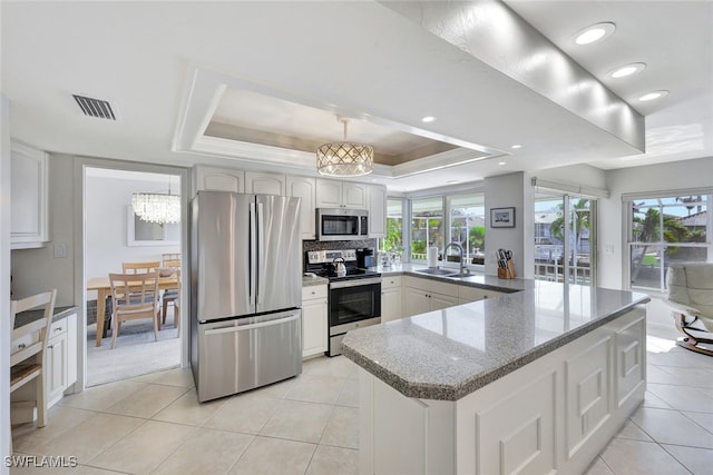 kitchen featuring white cabinets, sink, a tray ceiling, plenty of natural light, and stainless steel appliances