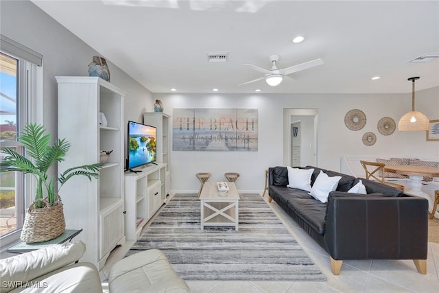 tiled living room with ceiling fan and a wealth of natural light