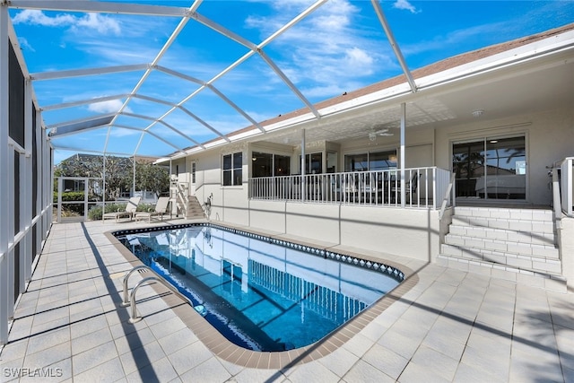 view of pool featuring ceiling fan, a patio area, and a lanai