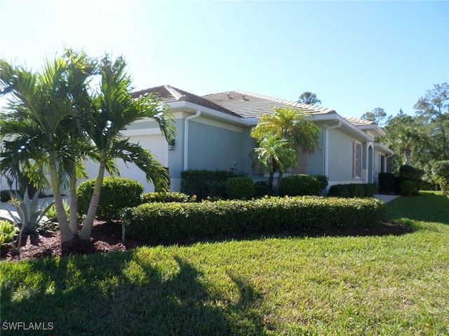 view of property exterior with a lawn and a garage