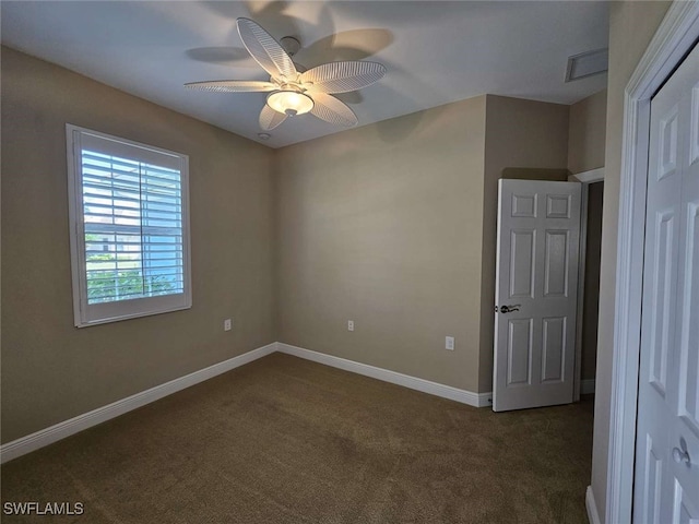 unfurnished bedroom with dark colored carpet and ceiling fan