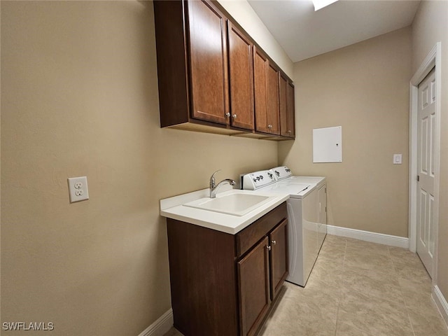 clothes washing area with washing machine and dryer, sink, and cabinets