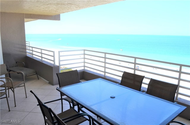 balcony with a water view and a view of the beach