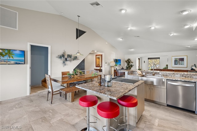 kitchen with light stone countertops, a kitchen breakfast bar, a center island, and stainless steel dishwasher