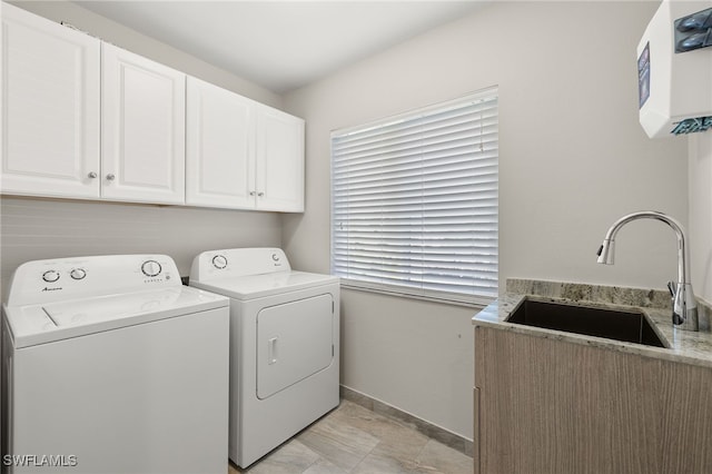 laundry room featuring cabinets, sink, and washer and dryer