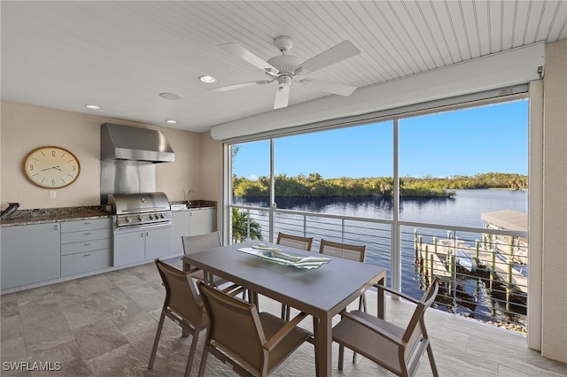 dining area with a water view, ceiling fan, and wood ceiling