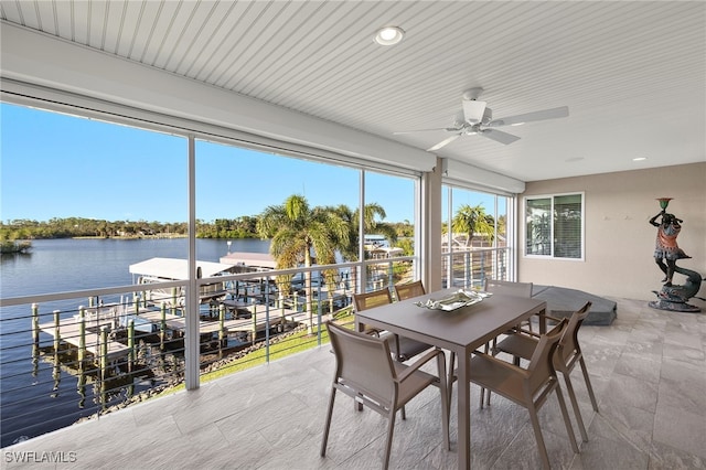 sunroom / solarium with ceiling fan and a water view