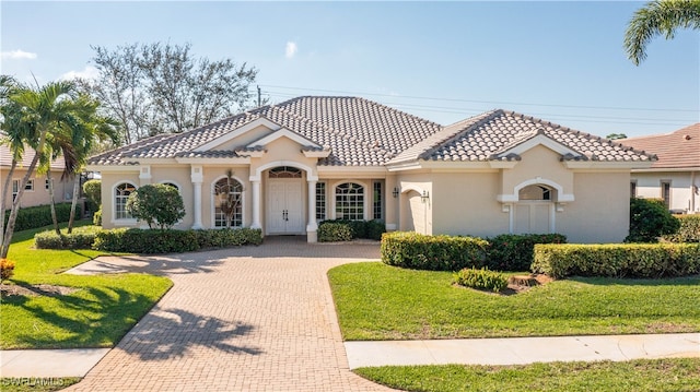 mediterranean / spanish-style house featuring a front yard