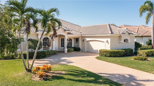 mediterranean / spanish-style home featuring a garage and a front lawn