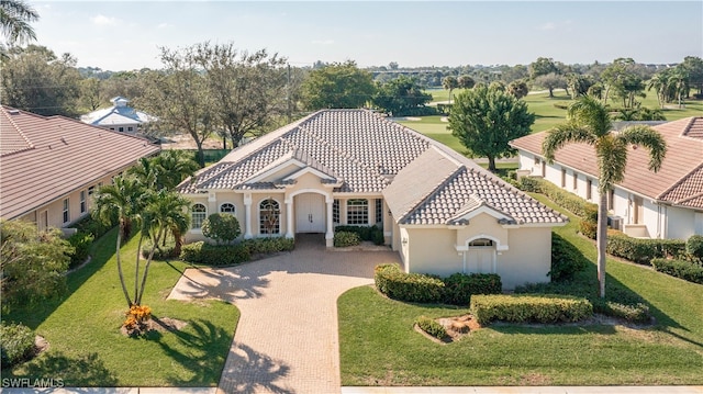 mediterranean / spanish home featuring a front lawn