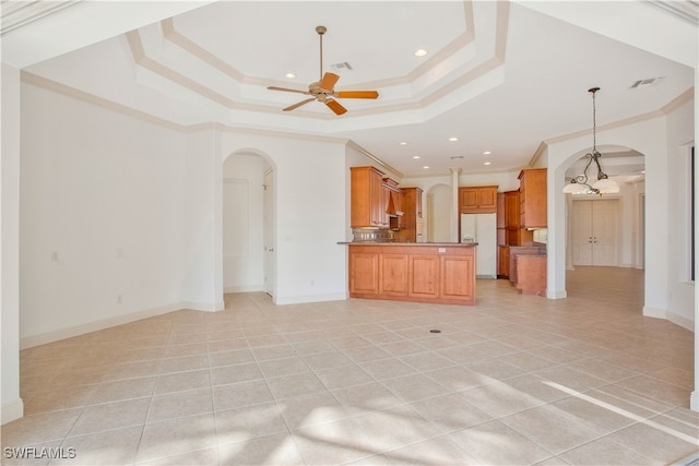 unfurnished living room with ceiling fan, a raised ceiling, light tile patterned floors, and crown molding