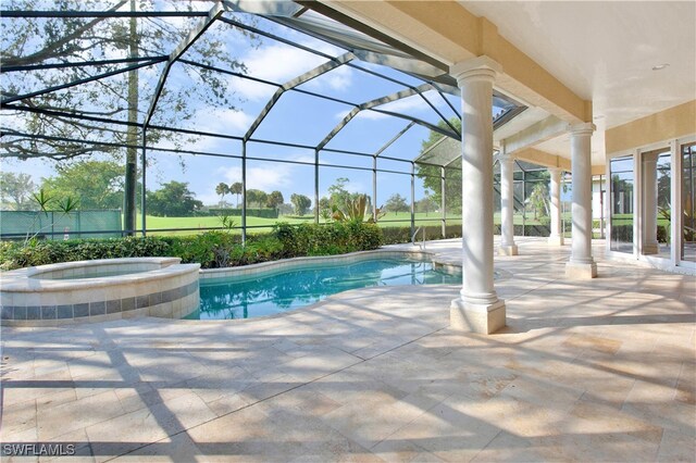 view of swimming pool with glass enclosure, an in ground hot tub, and a patio