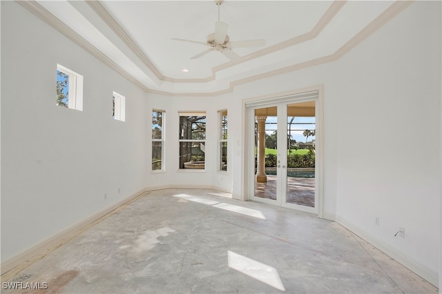 empty room featuring a tray ceiling, crown molding, and ceiling fan