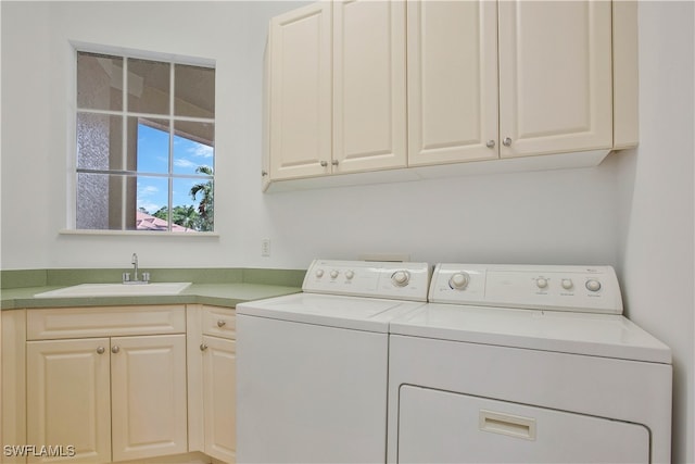 washroom featuring washer and clothes dryer, sink, and cabinets