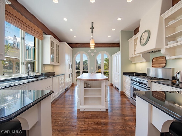 kitchen with dark hardwood / wood-style flooring, white cabinetry, stainless steel range, and decorative light fixtures