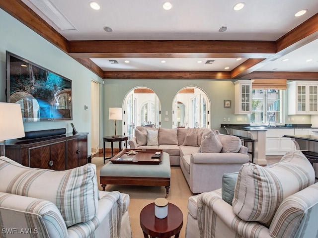 living room featuring sink and beamed ceiling