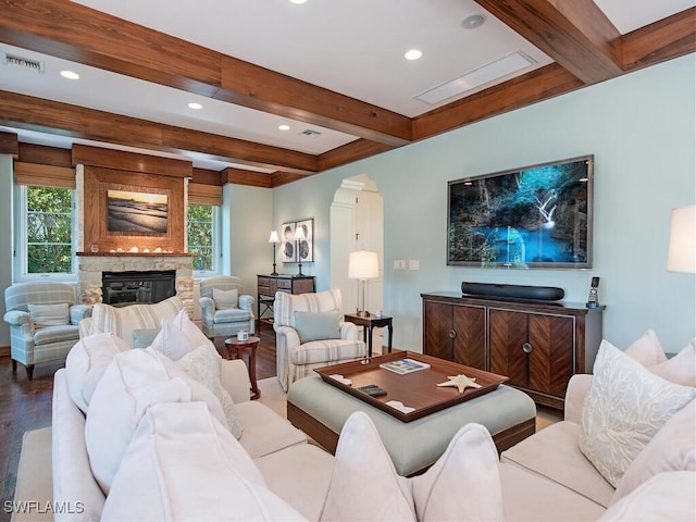 living room featuring beamed ceiling, hardwood / wood-style flooring, and a fireplace