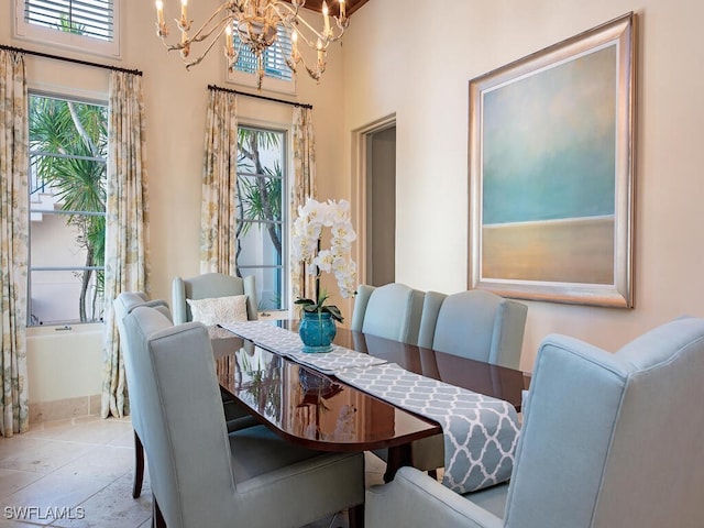 tiled dining area featuring a towering ceiling and an inviting chandelier