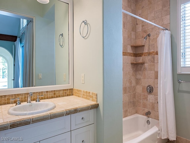 bathroom featuring vanity, shower / tub combo with curtain, and a wealth of natural light