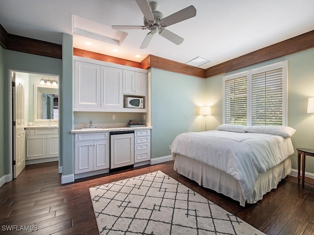 bedroom featuring ceiling fan, dark hardwood / wood-style flooring, sink, and connected bathroom