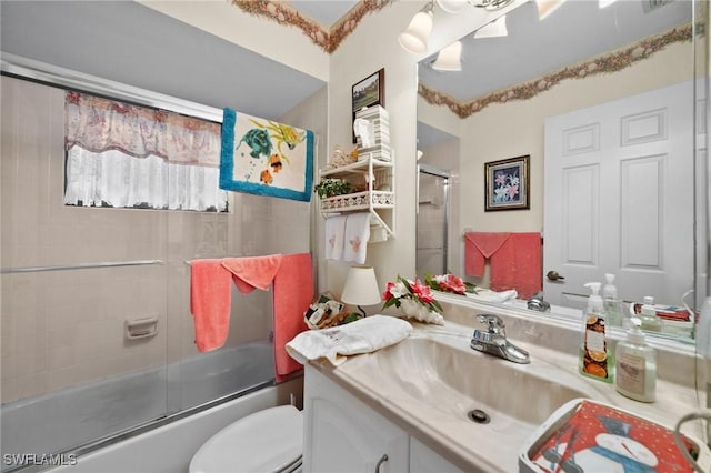 full bathroom with toilet, vanity, and combined bath / shower with glass door