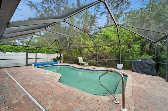 view of pool featuring a lanai, a patio area, and a grill