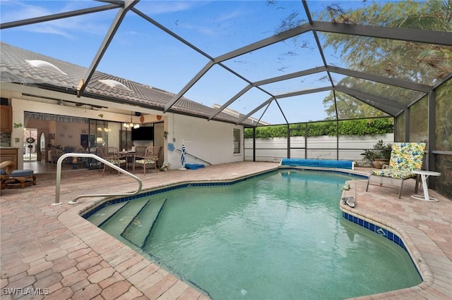 view of pool with glass enclosure and a patio