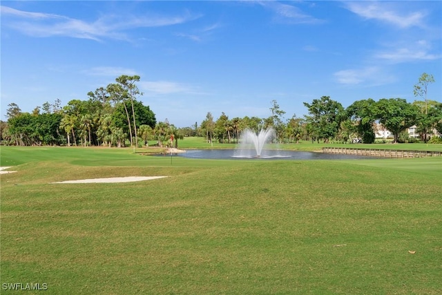 view of home's community with a water view and a lawn