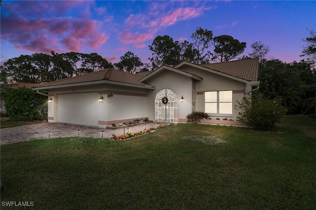 view of front facade with a yard and a garage