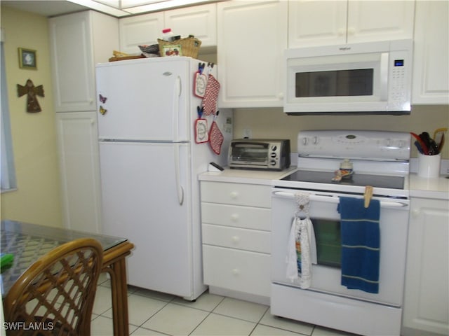 kitchen with white cabinetry, white appliances, and light tile patterned floors