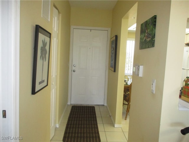 doorway with light tile patterned flooring