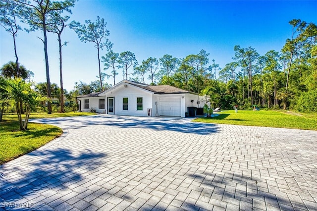 ranch-style home with a garage and a front lawn